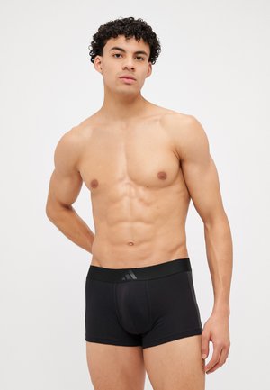 Schwarze Boxer-Briefs mit glatter Textur, elastischem Bund und dezentem Branding auf der Vorderseite. Die Passform ist figurbetont im mittellangen Stil.