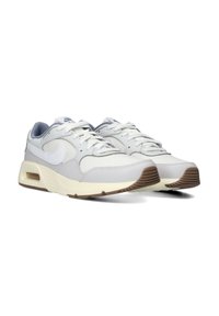 Zapatillas deportivas de color gris claro con una parte superior de cuero y malla, acentos en blanco, diseño con cordones y una suela beige con una banda de rodadura de goma marrón.