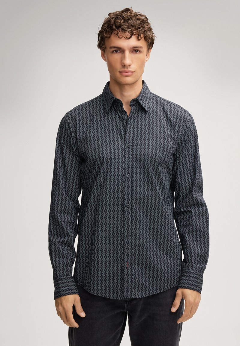 Camicia a maniche lunghe con bottone di colore blu scuro con un motivo zigzag fluttuante. Presenta un colletto classico e taglio dritto, realizzata in tessuto misto cotone.