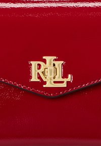 Κόκκινη πατέντα δερμάτινη τσάντα με χρυσό λογότυπο RL. Λείος υφής με κομψό σχέδιο και αντίθεση μαύρων άκρων.
