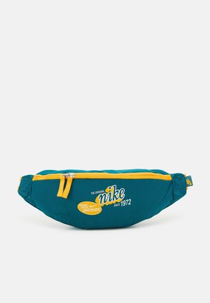 Nike heuptasje in blauwgroen en geel met rits aan de voorkant, merktekst "The Original Nike Since 1972" en slogan "Fresher, Cooler, Swoosher!"