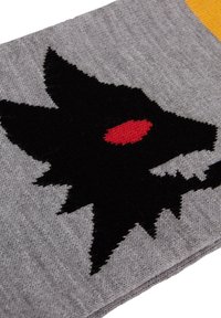 Grijze gebreide stof met een opvallende zwarte wolf silhouet met een rode ogen. Het ontwerp bevat scherpe vachtaccenten en textuurdetails.