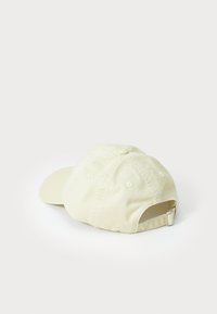 Yellow cotton baseball cap with a curved brim, adjustable strap at the back, and ventilation eyelets on the crown.