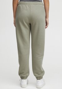Olivgrüne Jogginghose aus weichem Material mit einem elastischen Bund, gerippten Bündchen und einer lässigen Passform. Ideal für die Freizeit.