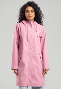 Pink waterproof raincoat with a hood, featuring snap closures and side pockets. Smooth texture and mid-length design.