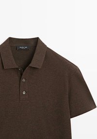 Brązowa koszulka polo z teksturowanej tkaniny. Posiada klasyczny kołnierzyk, plisę na trzy guziki oraz krótkie rękawy. Metka z napisem „Massimo Dutti”.