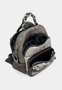 Kleiner grauer und beiger Rucksack mit geflochtenem Griff, mehreren Reißverschlusstaschen und dezentem Druckdesign auf der vorderen Tasche.