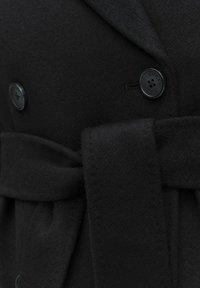 Zwarte wol coat met een dubbelzijdig ontwerp, een gladde textuur, grote knopen en een bijpassende stoffen riem die op de taille is gestrikt.