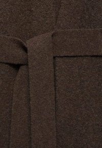 Cardigan en laine marron avec une texture douce, doté d'une large ceinture et de bords réguliers. Le tissu est dense et chaud, présentant des variations subtiles de couleur.