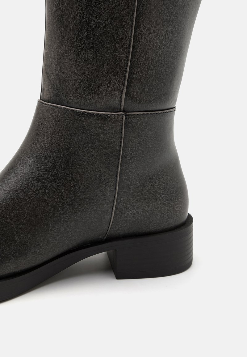 Czarne skórzane botki sięgające do kolan o gładkiej fakturze, kwadratowym nosie i niskim słupkowym obcasie. Wyposażone w dyskretne hafty wzdłuż szwu.