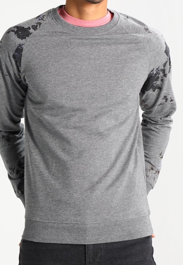 Sudadera gris con mangas raglán que presenta un sutil patrón floral negro. Fabricada en un tejido suave con puños y dobladillo acanalados.