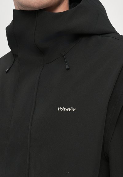Melna kapuce ar augstu apkakli, regulējamiem aukliņām un izšūtu "Holzweiler" logo baltā krāsā. Mīksta auduma ar matētu apdari.