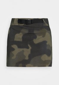 Minifalda con patrón de camuflaje hecha de tela de malla, con un cinturón negro con hebilla. Predominantemente en tonos verdes y oscuros, con una superficie texturizada.