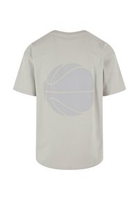 Gaišpelēka īsām piedurknēm t-krekls ar lielu, izsmalcinātu basketbola grafiku uz muguras. Kokvilnas audums ar gludu tekstūru.