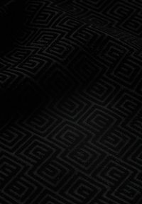 Tela negra con un patrón que presenta un diseño texturizado con motivos de cuadrados interconectados. La superficie parece suave y esponjosa con un ligero brillo.