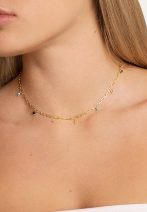 Le collier en chaîne en or se compose de maillons allongés, ornés de petites pierres précieuses colorées en bleu, rose, noir et jaune.
