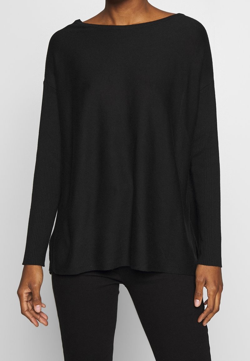 Czarny dziany sweter z szerokim dekoltem w kształcie łódki, opuszczonymi ramionami, żebrowanymi długimi rękawami i luźnym krojem. Gładka faktura, minimalistyczny design.