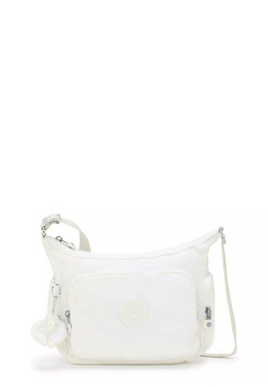 White crossbody bag featuring soft material, a main zip compartment, front pocket, and a removable charm. Adjustable strap and logo detail.