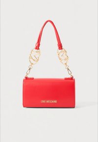 Red Love Moschino handbag with gold heart-shaped chain links and a short handle, set against a plain white background.