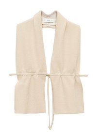 Beige knitted vest with open front, shawl collar, and adjustable tie at the waist. Soft texture, unstructured design, and no fastenings.
