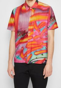 Chemise à manches courtes en tissu léger avec un motif abstrait audacieux multicolore aux tons rose, rouge et bleu, avec une poche.