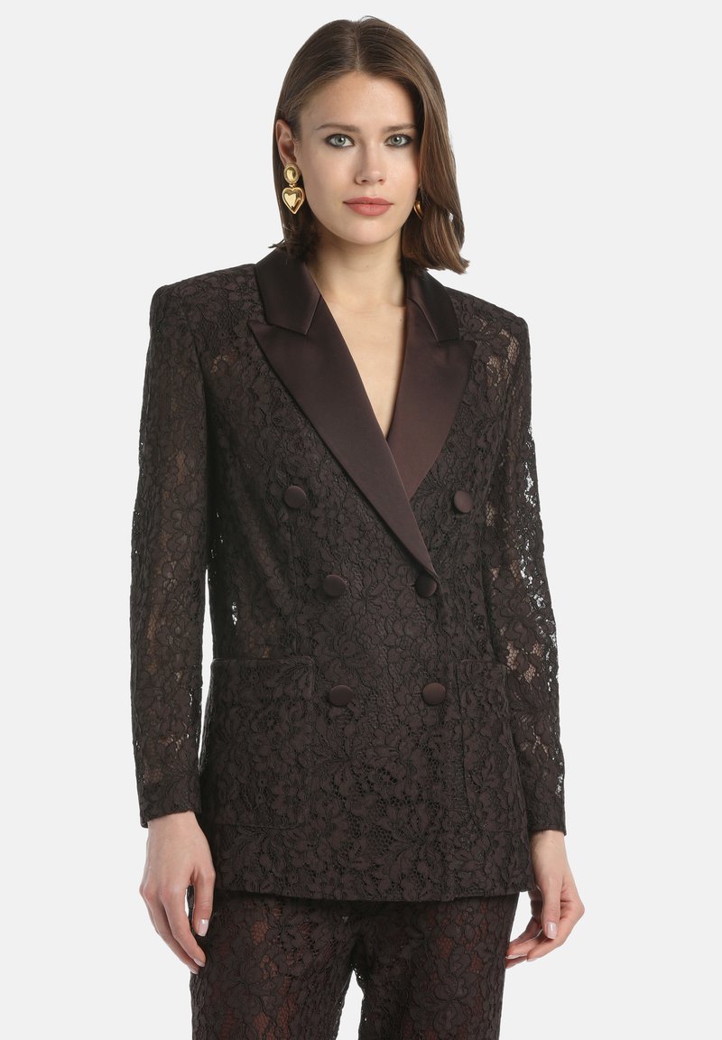 Sacou dublu din dantelă neagră, cu guler din satin cu colțuri, butoane decorative și modele florale; are mâneci lungi din dantelă și buzunare laterale.