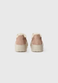 Scarpe ankle in suede rosa chiaro con bordo in finta pelliccia bianca, dotate di una suola spessa beige e dettagli cuciti lungo i bordi.
