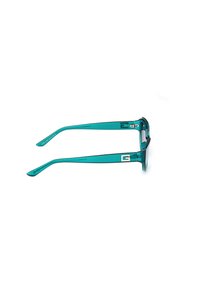 Gafas de sol turquesas con montura rectangular, lentes transparentes y varillas delgadas y rectas que presentan un detalle de logo.