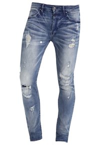 Chude dżinsy w jasnoniebieskim kolorze z przetarciami, widocznym blaknięciem i wieloma przetarciami, z pięcioma kieszeniami i zapięciem na guziki.
