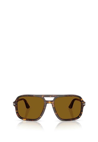 Gafas de sol de carey con forma cuadrada, lentes marrones, un puente nasal pronunciado y una textura suave. Las varillas presentan curvas sutiles.
