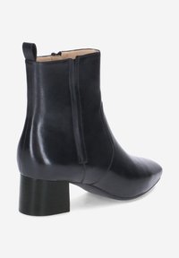 Schwarze Lederstiefelette mit niedrigem Blockabsatz, seitlichem Reißverschluss, abgerundetem Quadratzehen und Zugschlaufe hinten.