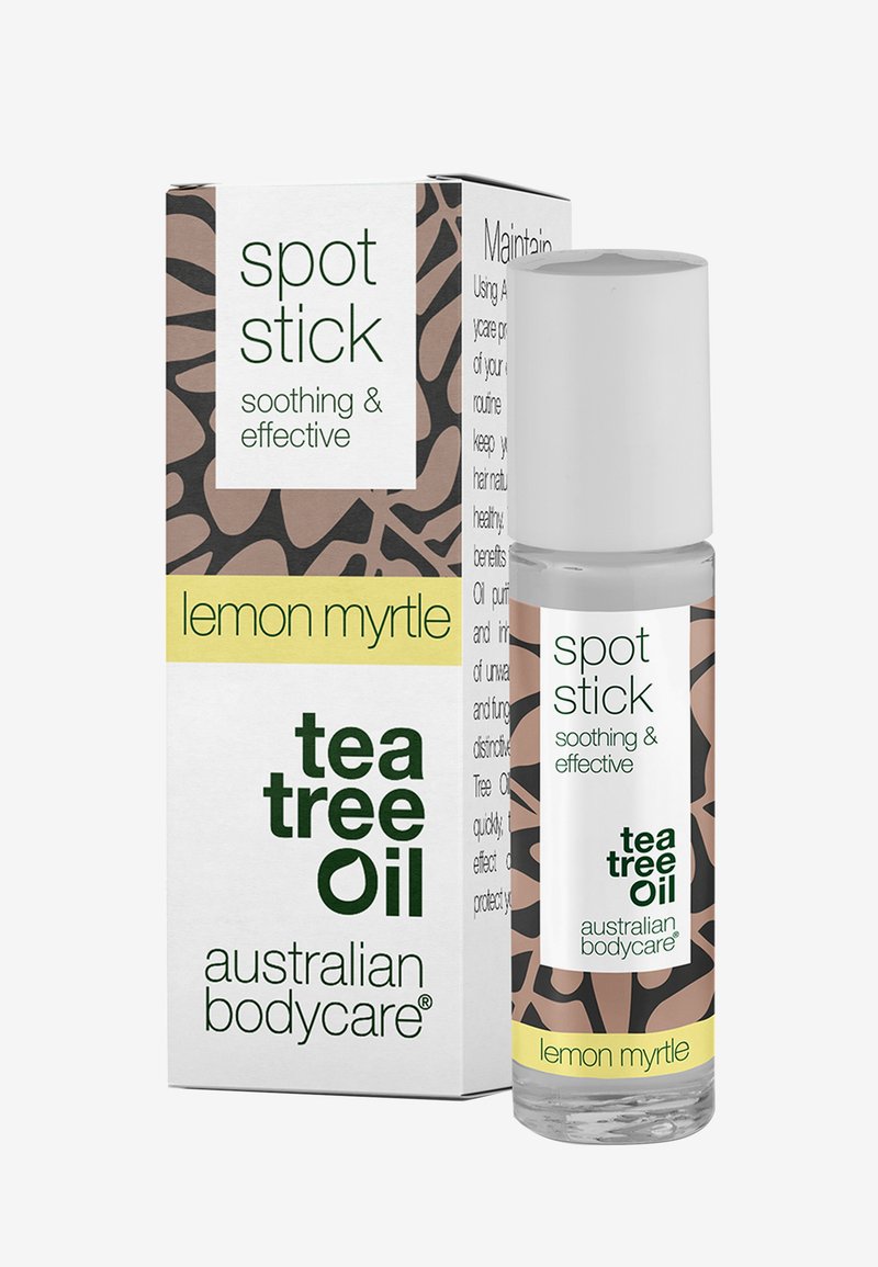 Tea tree olie pletstick i gennemsigtig tube med hvidt låg. Æsken viser et brunt og cremefarvet abstrakt mønster med grøn tekst.