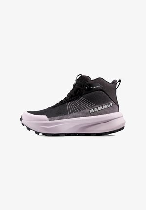 Scarpa da trekking a metà altezza nera e rosa chiaro con suola spessa, etichetta Gore-Tex, lacci e nome del marchio Mammut sul lato.