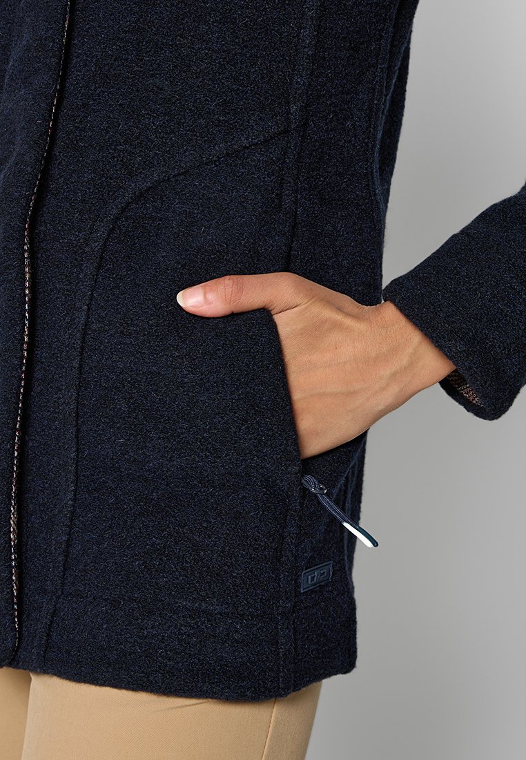 Marineblaue Fleecejacke mit strukturiertem Finish, ausgestattet mit seitlichen Reißverschlusstaschen, kontrastierenden Nähten und einem verstellbaren Saum mit Zugkordel.