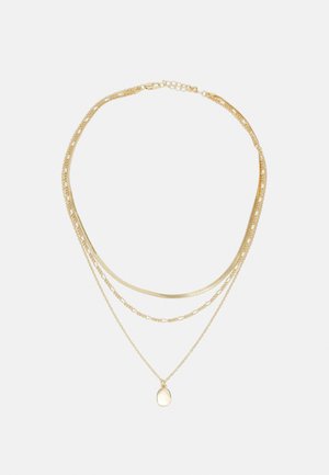 Collana a più strati in tono oro, caratterizzata da catene di diverse spessore, una delle quali presenta un piccolo ciondolo ovale. Presenta elementi lisci e testurizzati.