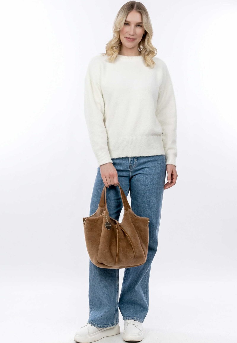 Sac à main en fausse fourrure marron avec des poignées doubles et une fermeture éclair. Texture douce, forme arrondie et un charme décoratif sont des caractéristiques notables.