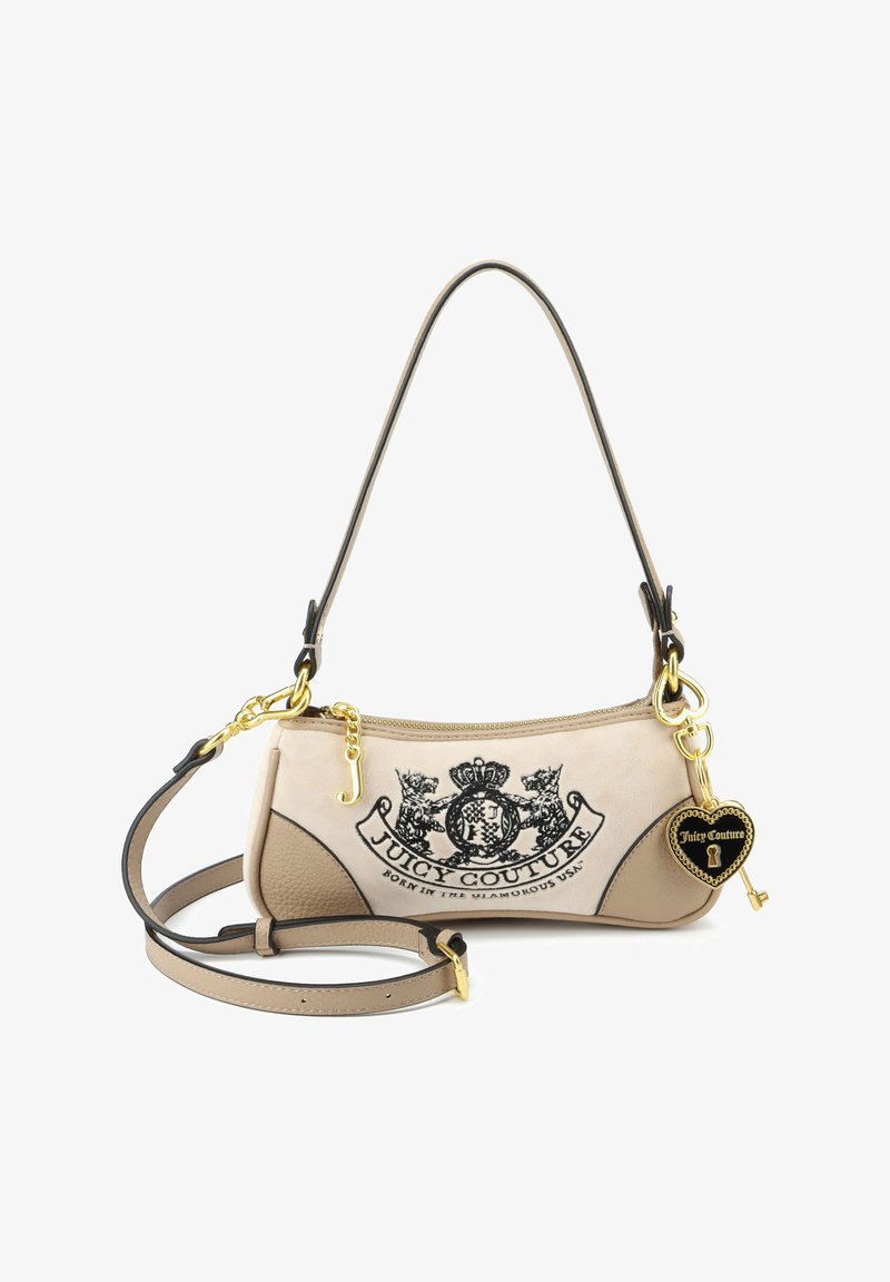 Kleine beige Juicy Couture-handtas met zwart geborduurd logo, gouden sleutel- en hartbedel, twee verstelbare riemen en ritssluiting.