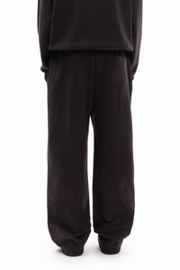 Fekete pamut melegítőnadrág laza szabással, hátul zsebbel és a szegélynél dombornyomott virágmintákkal. Puha tapintású, egyenes szárú dizájn.