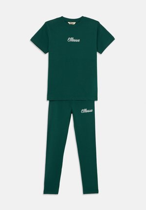 Conjunto de algodón verde que consiste en una camiseta de manga corta con el logotipo bordado "Ellesse" y leggings a juego, ambos con una textura suave.