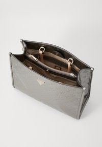 Borsa a mano in pelle verniciata grigia con design strutturato. Presenta un motivo con logo, hardware dorato e molteplici scomparti interni per l'organizzazione.