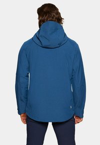 Niebieska wodoodporna kurtka z kapturem, teksturowana tkanina, aerodynamiczny fason oraz boczne kieszenie. Posiada lekko zaokrąglony dół i regulowane mankiety.