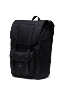 Black fabric backpack with a flap closure, two adjustable straps, and a front pocket. Features sturdy construction and padded back panel.