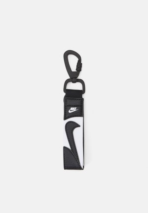 Zwart-witte Nike sleutelhanger van leer, met een opvallend zwart logo accent en een karabijnhaak voor bevestiging.