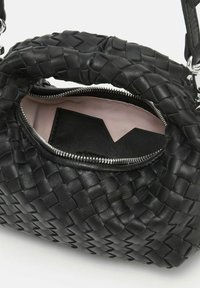 Sac à main en cuir tressé noir avec une ouverture zippée, révélant un intérieur rose et un porte-cartes noir. À noter, de robustes poignées tressées.