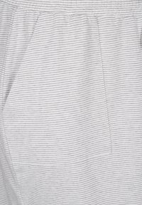 Gray and white striped fabric, featuring a soft texture, with an elastic waistband and side pocket detail. Casual bottom wear design.
