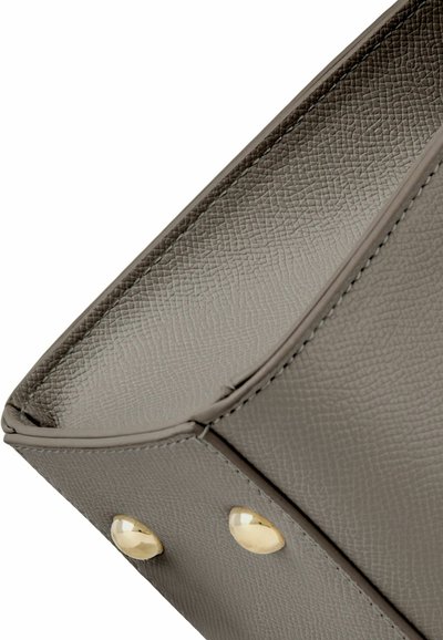 Siva teksturirana usnjena torbica, kot z dvema okroglima zlatima kovinskima zatičema na spodnjem robu.