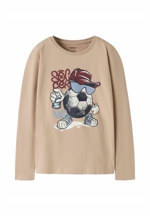 Beige langærmet skjorte med tegneserie-fodboldkarakter iført en rød kasket, blå solbriller, sneakers og holder en spraymalingsdåse.