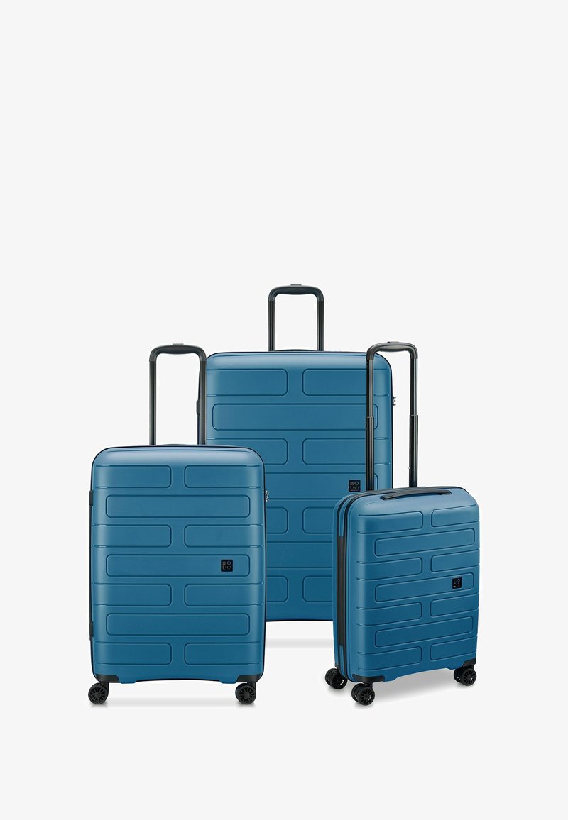 Tres maletas rígidas azules de diferentes tamaños, con superficies texturizadas y patrones rectangulares, y cuatro ruedas para facilitar su movilidad.