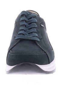 Baskets en daim bleu foncé avec des lacets plats, semelle blanche, accents cousus et bout arrondi. Présente une texture lisse et un design épuré.