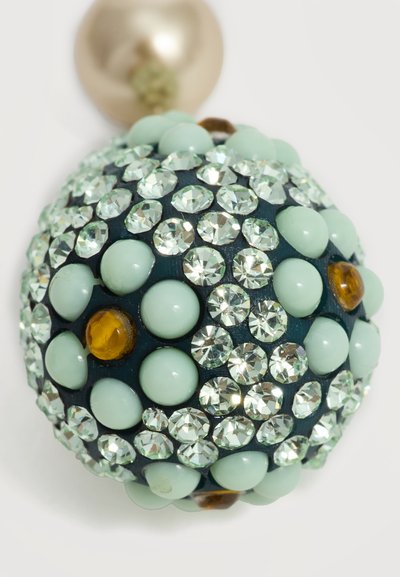 Boucle d’oreille ronde composée de perles vert clair groupées, de strass transparents et de petites pierres ambrées sur fond sombre avec attache à clou dorée.